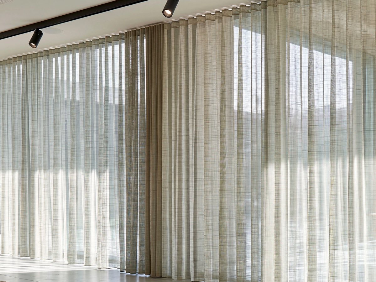 Schwer entflammbare Vorhänge nach Maß für den Objektbereich in Österreich – lichtdurchlässige Vorhänge an einer Fensterfront